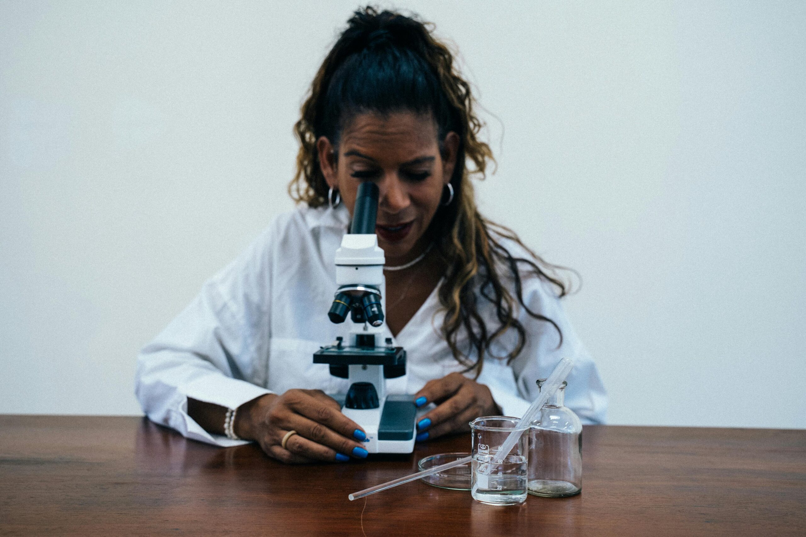 A woman using a microscope in a laboratory setting, showcasing scientific research.